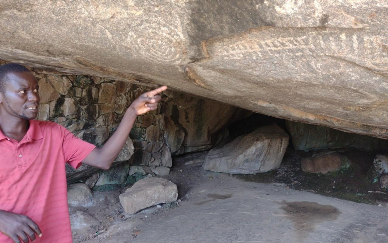 Local guide explaining Nyero Rock Paintings