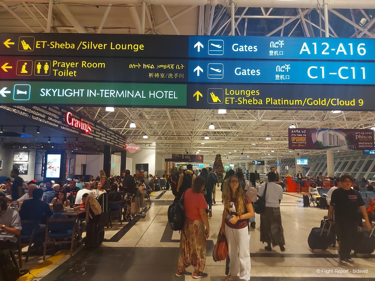 Passengers inside Addis Ababa Bole Airport terminal with modern facilities and seating areas